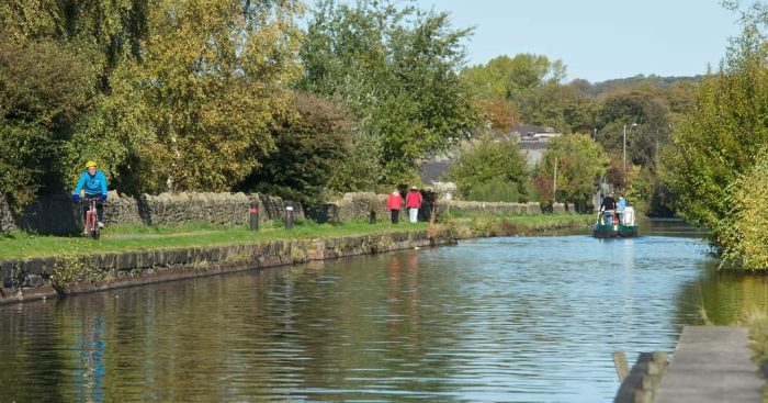 A group of walkers in the distance on a canal towpath