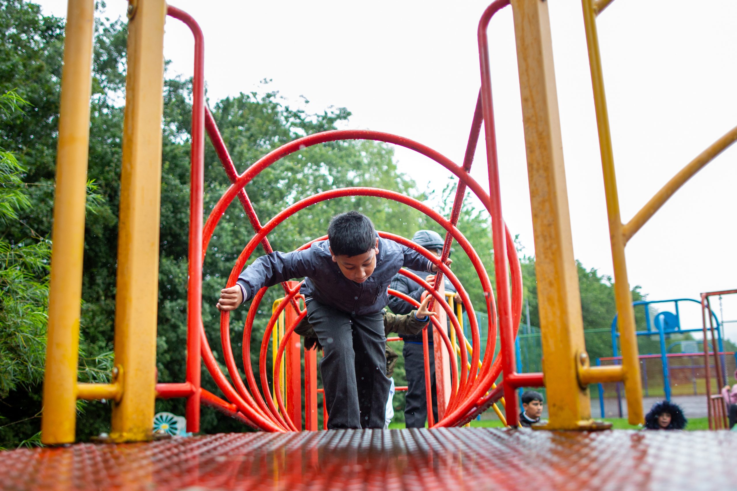 Male child climbing through a tunneled climbing frame