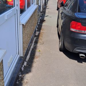 Cars parked on kerbs with limited space for pushchairs and wheelchairs to pass.